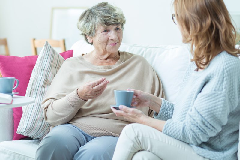 Riverview Hospice and Palliative Care LLC | two woman sitting on a couch discussing care options drinking tea