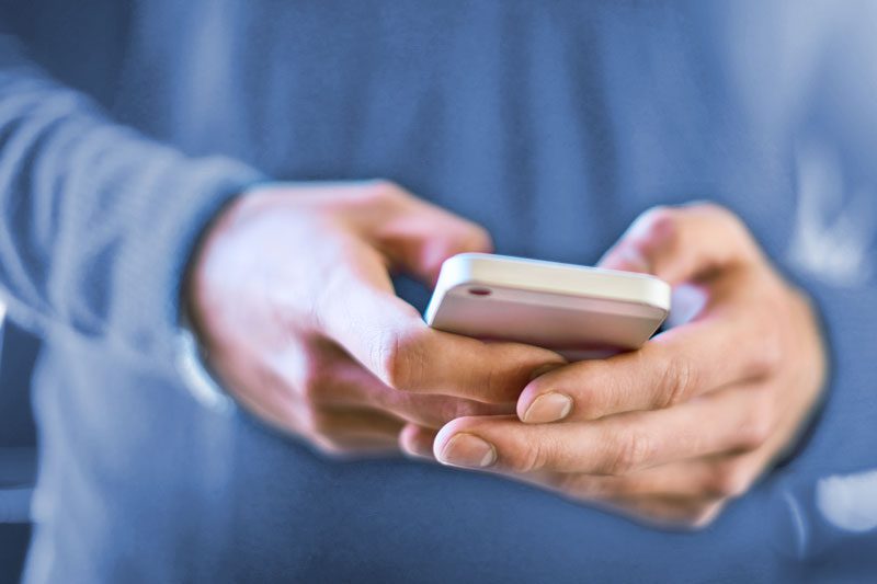 Riverview Hospice and Palliative Care LLC | A close up of a man's hands holding a smart phone dialing a phone number contacting Riverview Hospice and Palliative Care LLC